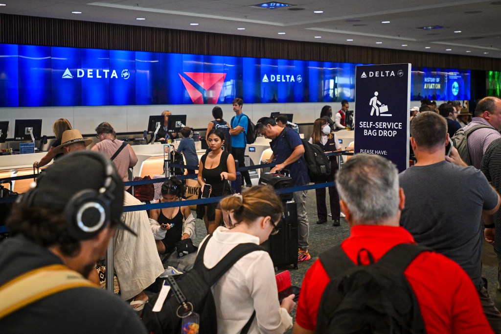 Passengers wait in long lines at check-in counters at Orlando International Airport, due to a global communications outage caused by CrowdStrike on July 19, 2024.